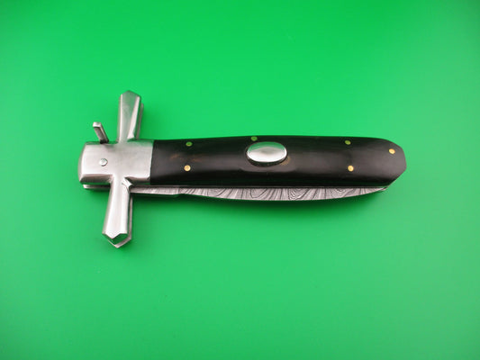 Knife with black handle and silver blade on a green background