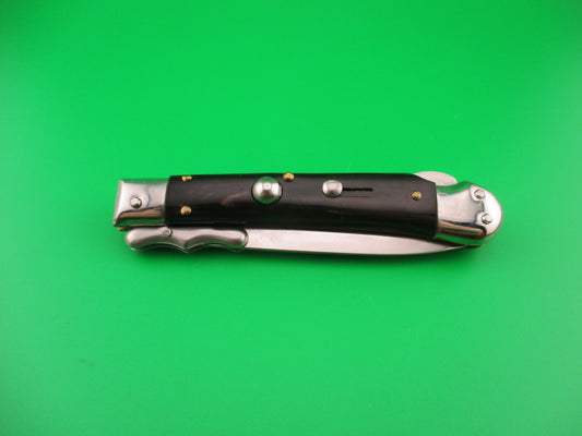 Pocket knife with black handles on a green background