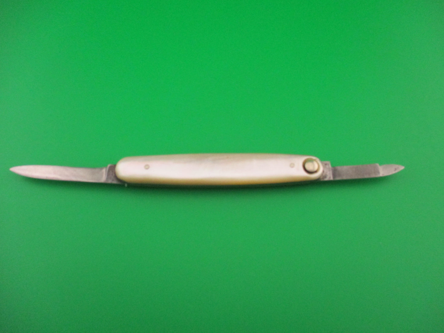 Knife with a white handle on a green background
