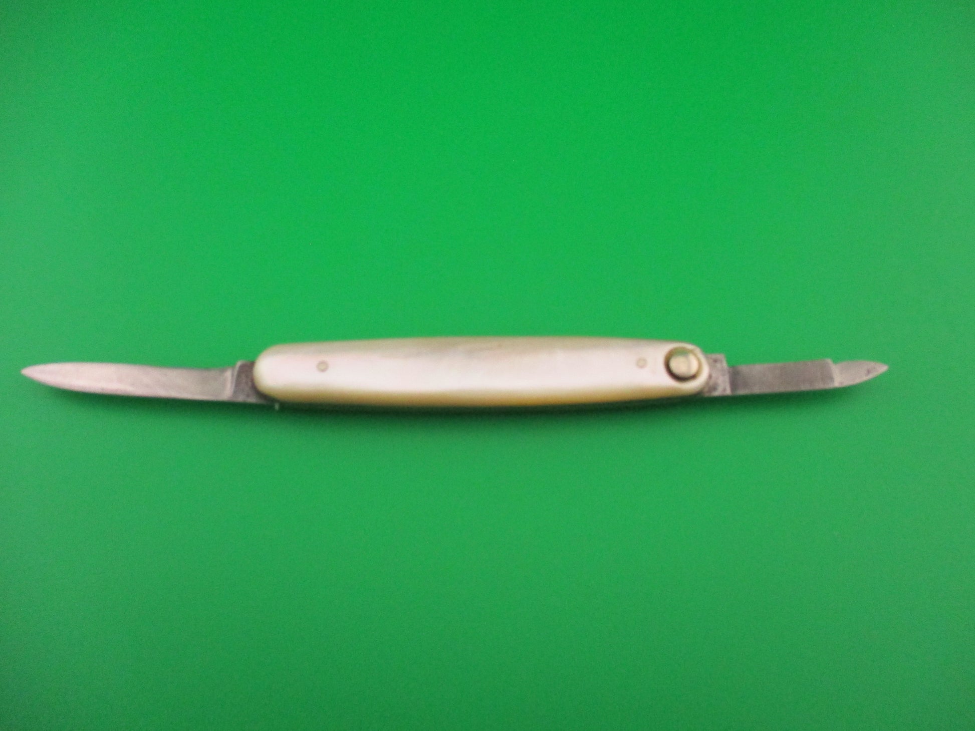 Knife with a white handle on a green background