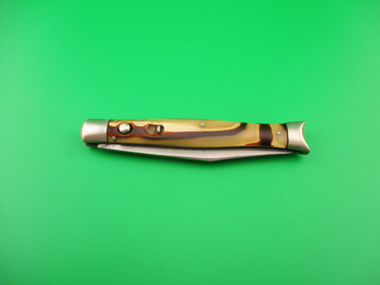Folding knife with a decorative handle on a green background