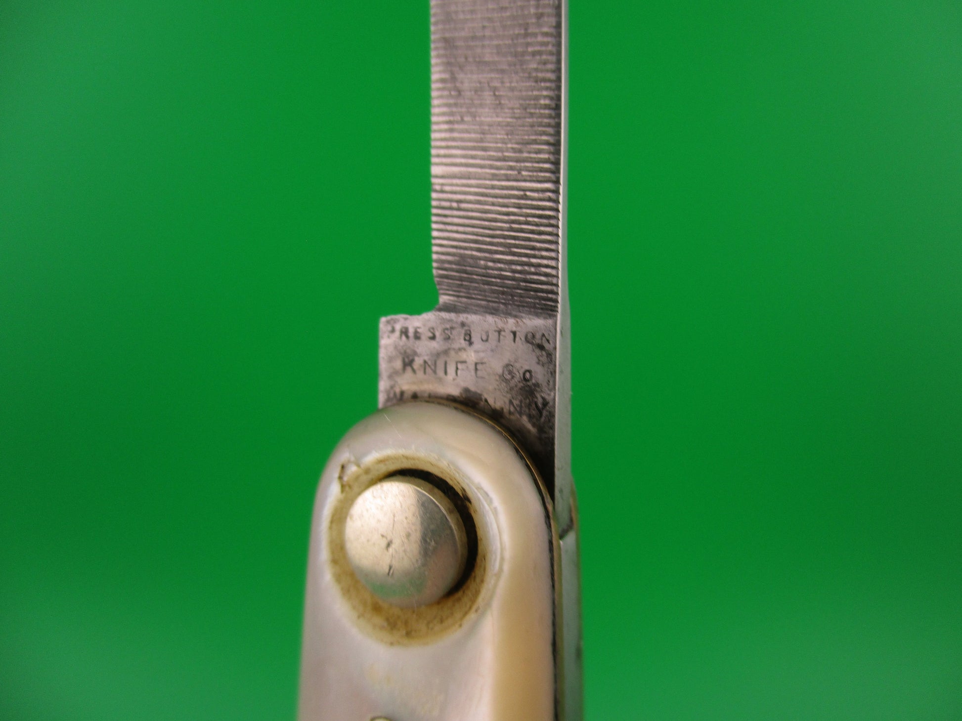 Close-up of a knife blade with a green background