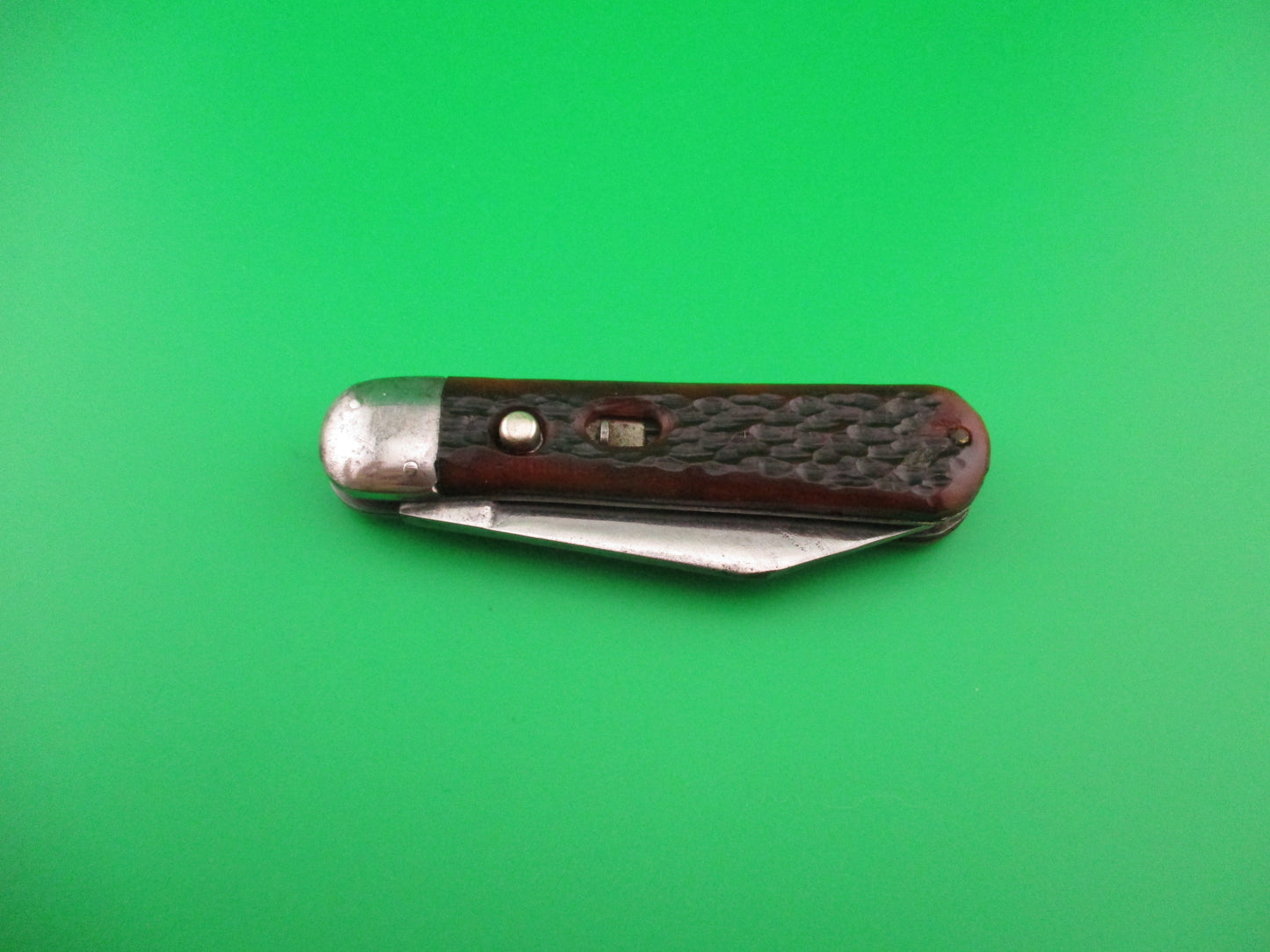 Pocket knife with brown handle on a green background
