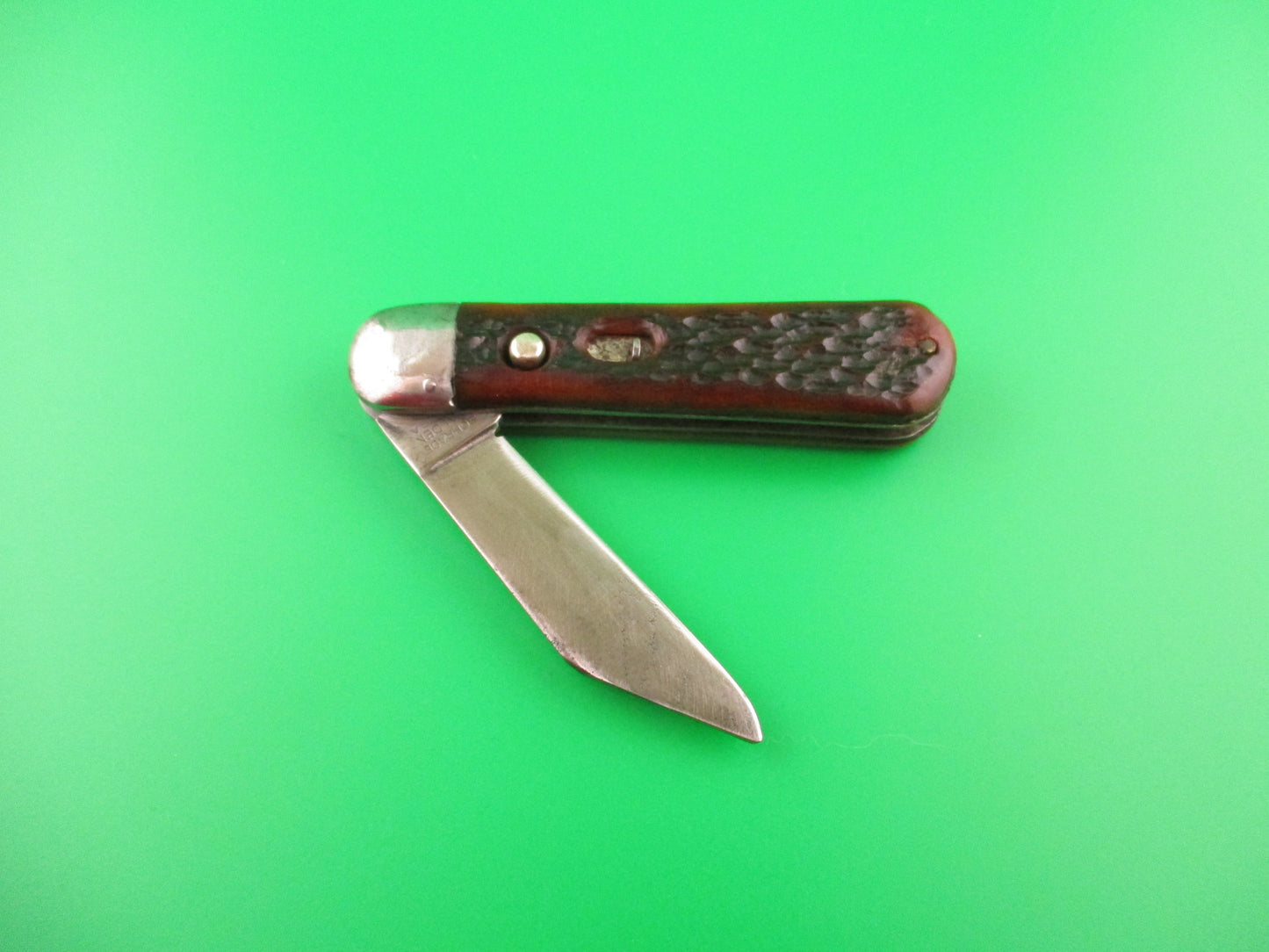 Pocket knife with a brown handle on a green background