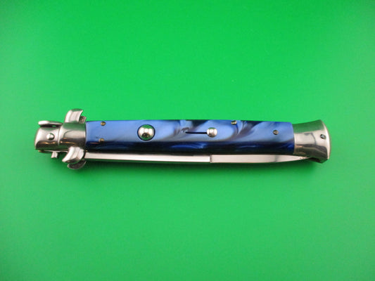 Folding knife with blue handle and silver blade on a green background