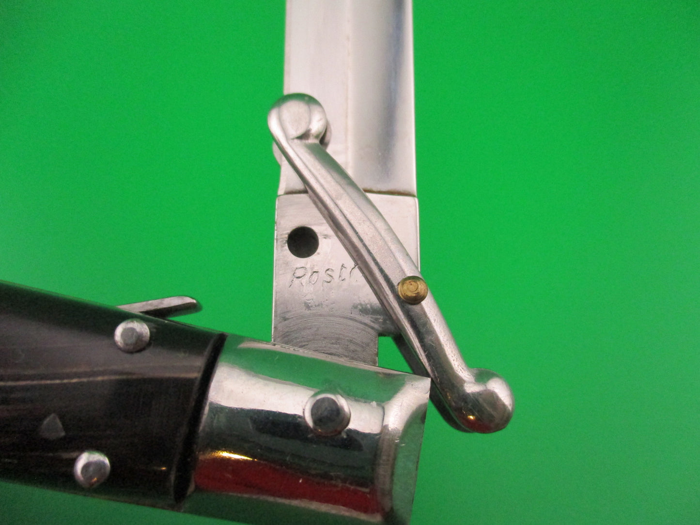 Close-up of a knife blade with 'Presto' branding on a green background