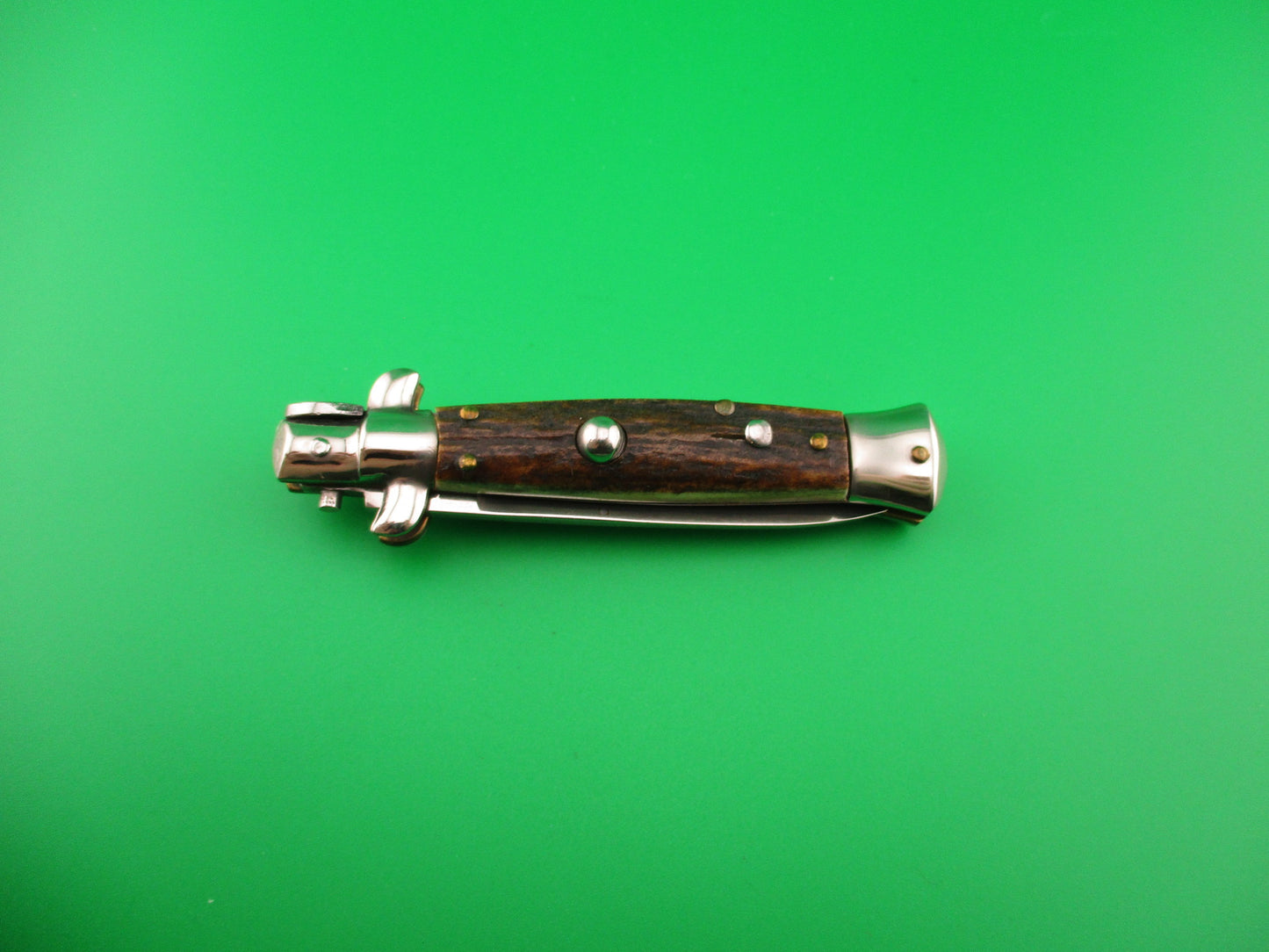 Wooden-handled tool on a green background