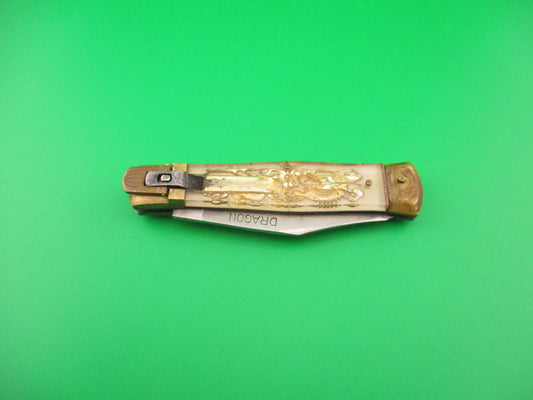 Foldable knife with decorative handle on a green background