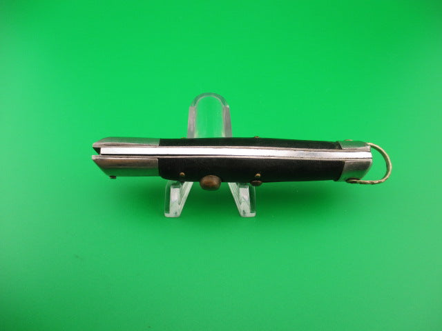 Black and silver pocket knife on a green background