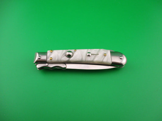 Folding knife with decorative handle on a green background
