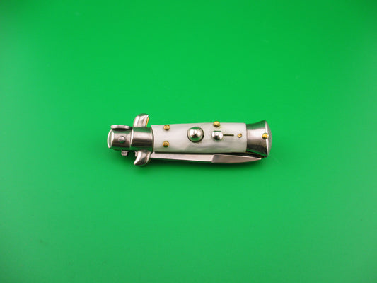 Metallic knife with buttons on a green background