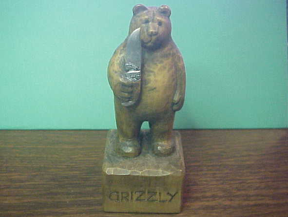 Hand Carved Grizzly Bear holding Kabar Grizzly knife by Bill Horgos